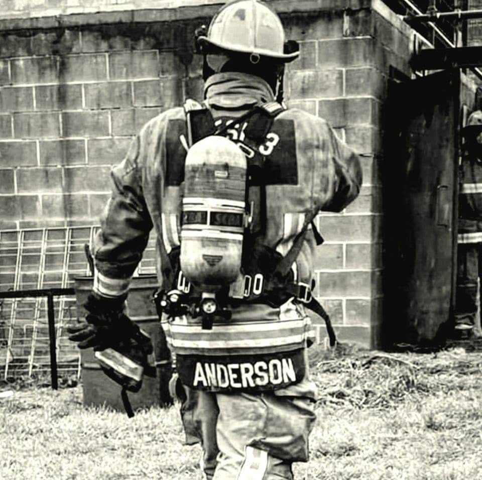 Daniel Anderson in fire turnout gear, ANDERSON across the coat